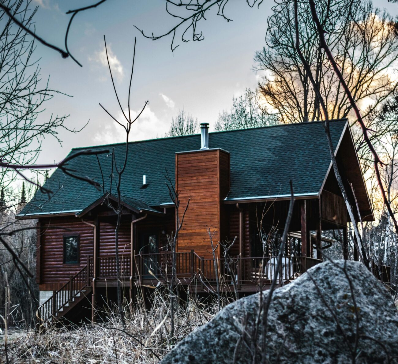 Wood stove installed in rustic off grid cabin with stone hearth
